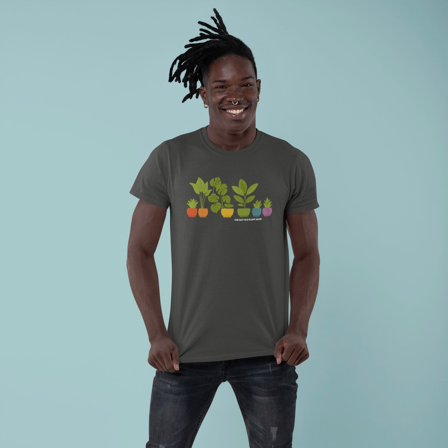 Man wearing a dark gray t-shirt with plant illustrations on a light blue background